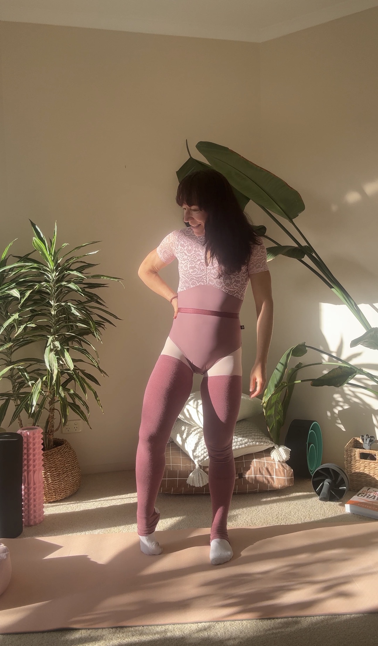 Kym after her weight loss journey, standing on a yoga mat